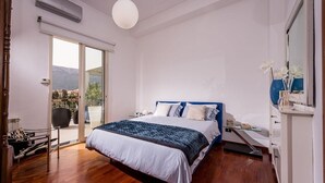 Une chambre à coucher comprenant un lit, une table de chevet, une commode et un balcon avec vue.