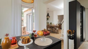 A modern kitchen with a dining area, featuring a fruit bowl on the counter, a coffee station, and a black refrigerator. - Villa Rossana, with pool near the sea (Plemmirio)