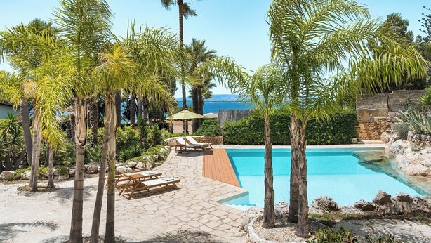 A pool area with lounge chairs and palm trees. - Villa Rossana, with pool near the sea (Plemmirio)