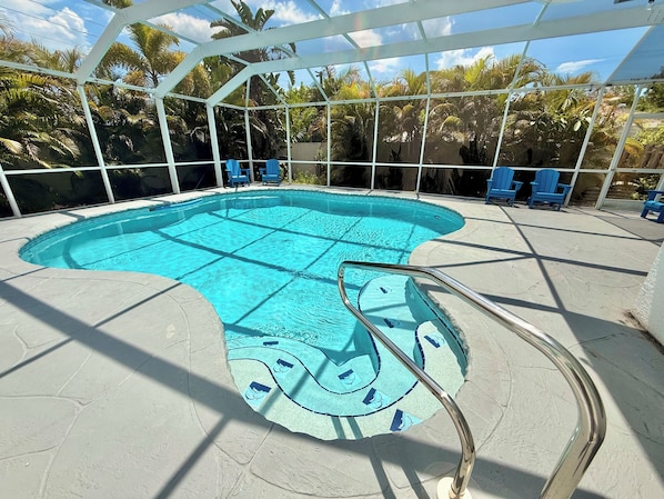 Une piscine au design original, entourĂ©e dâun espace abritĂ© agrĂ©mentĂ© de chaises.