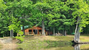A cabin surrounded by trees and a body of water. - Cabin getaway on the Menominee River  (Wallace)