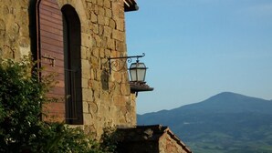 Edifici de pedra amb una porta de fusta i un fanal.