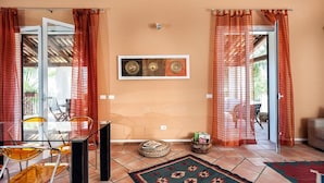A room with a glass table and chairs, a woven basket, a patterned rug, and a framed artwork on the wall. - Casa Maissala Due, with shared pool near sea (Marsala)
