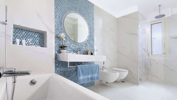 A modern bathroom with a freestanding bathtub, a vanity with a mirror, a toilet, and a shower area.