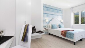 Een moderne slaapkamer met een bed, nachtkastjes, een bureau en een laptop.