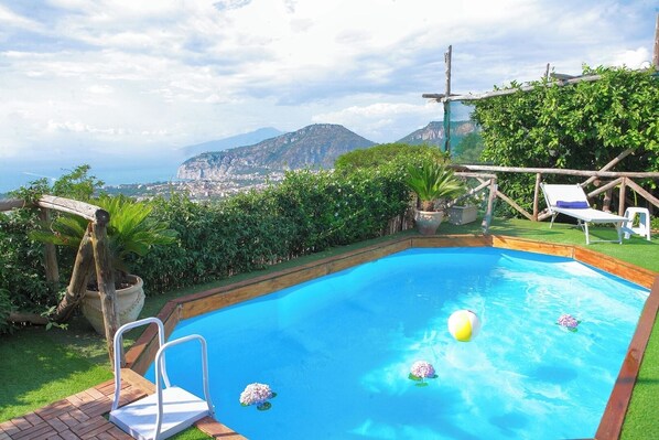 A swimming pool with a view of a city and mountains in the background.