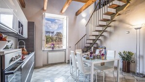 Una cocina moderna con comedor, un ventanal grande y una escalera.