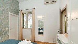 Una camera da letto con un letto, una finestra con tende, uno specchio e un armadio bianco.