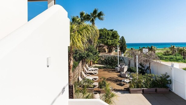 A balcony with a view of the sea, outdoor seating, and potted plants. - Corrado Residence (Blu) - Apartment near Marzamemi (Reitani)