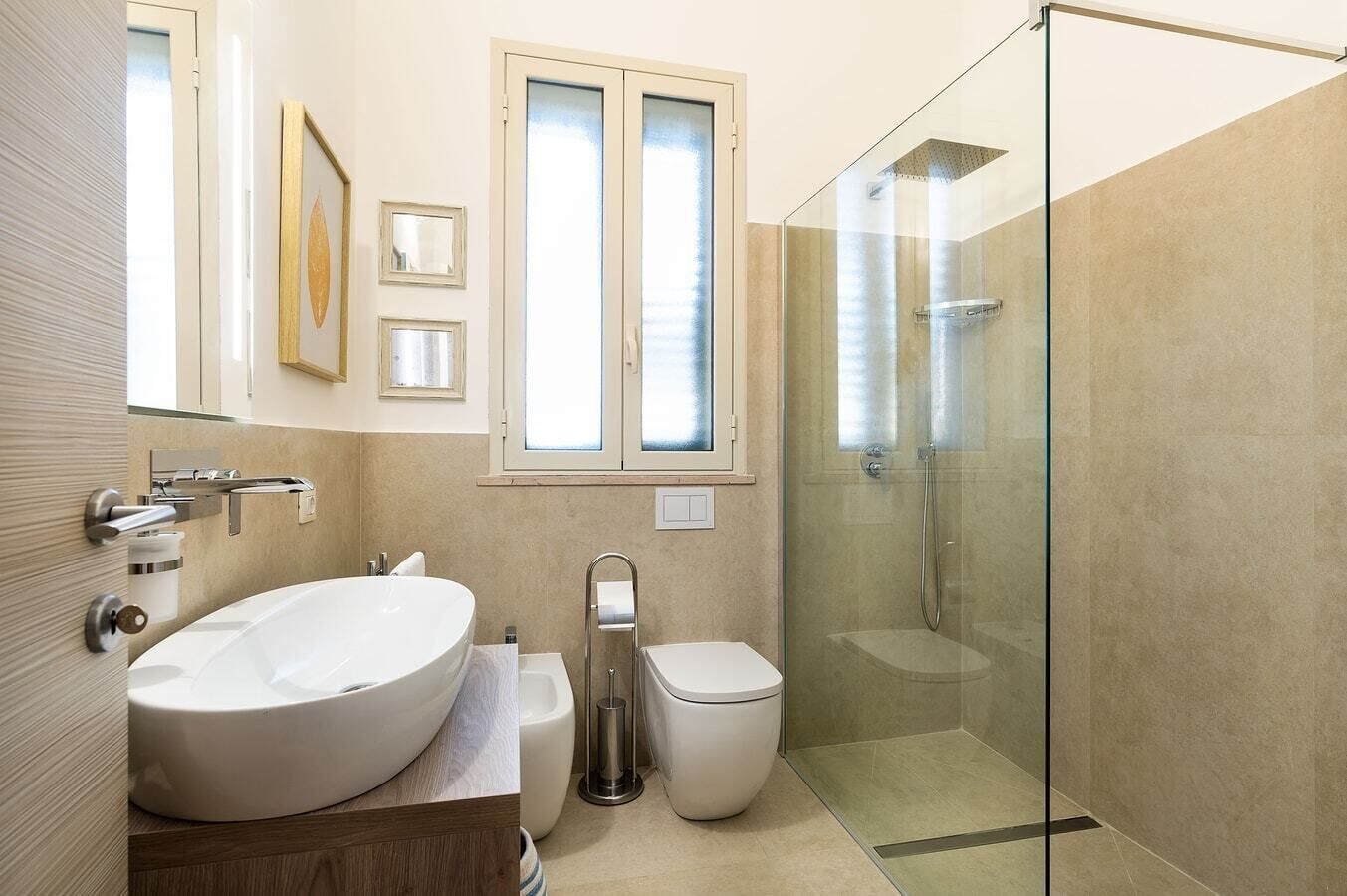Une salle de bain moderne avec une baignoire sur pieds, des toilettes et une douche à parois de verre.