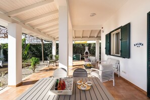 A covered outdoor patio with a table set for drinks, a grill, and seating. - Corrado Residence (Acqua) near Marzamemi (Reitani)