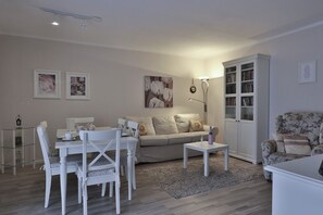 Relax in this inviting living space, featuring a dining area, comfortable sofa, and floor lamp.