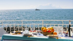 A table set with fruits and glasses, overlooking a calm sea with a distant island. - Villa Mia - Sea front private villa close to town (Napoli)