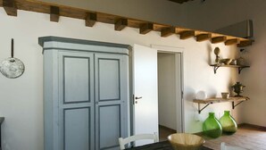 A room with a wooden ceiling, a white door, and a table with a bowl. There are shelves with decorative items and green vases. - Ragusa Apartments (Blu) - apartment near Ragusa (Ragusa)