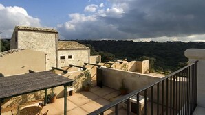 A rooftop terrace with a view of a stone building and a hillside. - Ragusa Apartments (Grigio) - apartment near Ragusa (Ragusa)