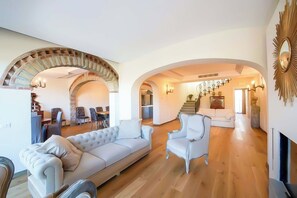 A spacious living area with a sofa, armchairs, and a fireplace.