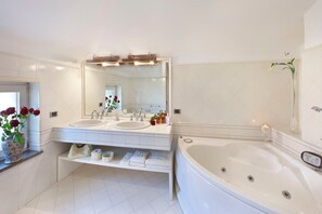 Ein modernes Badezimmer mit zwei Waschbecken, einer großzügigen Badewanne und einem Waschtisch mit Stauraum.