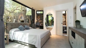 Una camera da letto con un letto grande, una scrivania e vista sugli alberi dalla finestra.