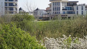 A modern urban area with multi-story residential buildings, a central open space, and surrounding greenery. - Der Zweckmäßig Ausgestattete Bungalow in Börgerende mit ca. 42 qm Wohnfläche Verfügt Über Eine gut Abgeschirmte Sonnenterrasse in Süd-/westlage (Börgerende)