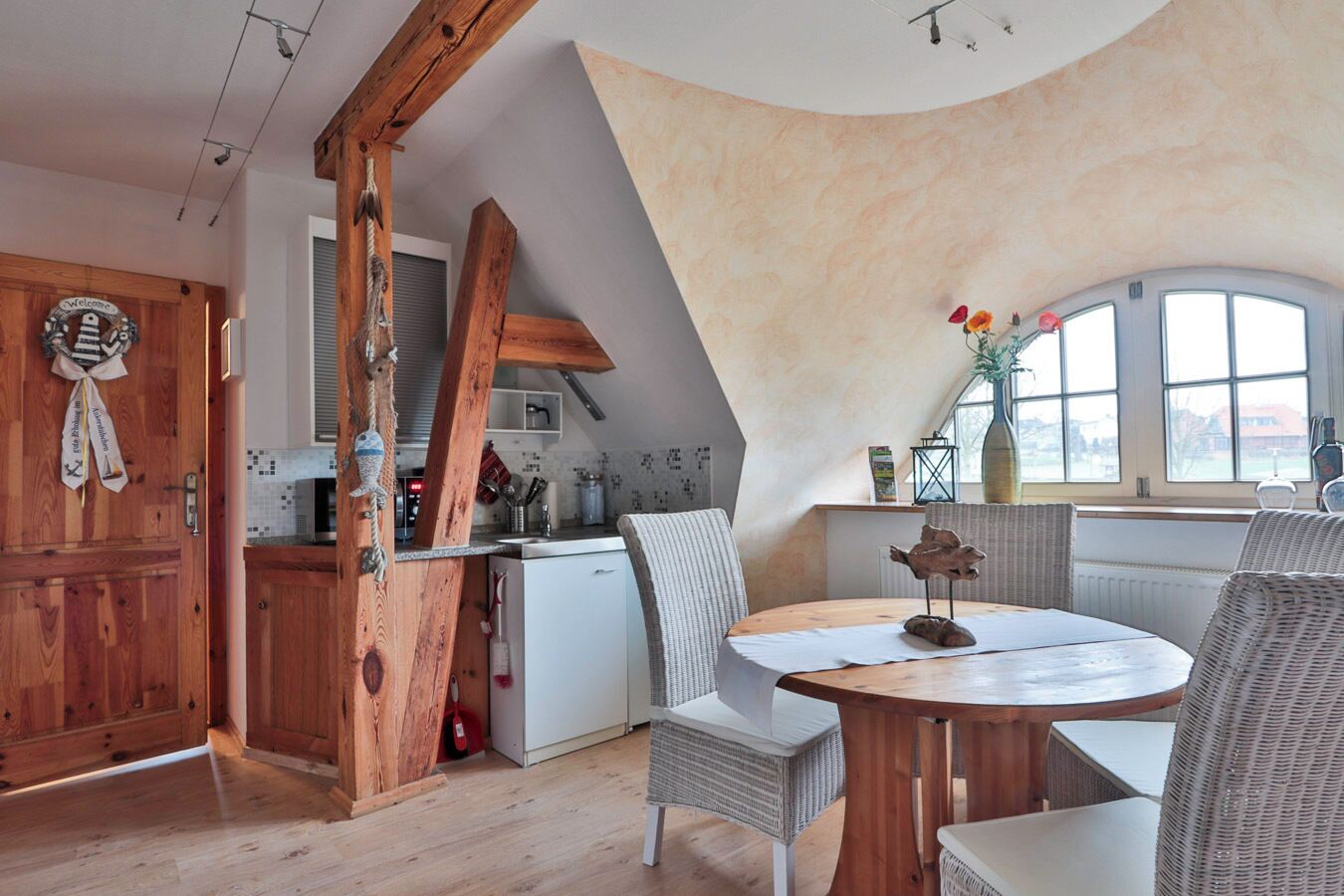 Ein Loft-Zimmer mit Essbereich, Küche und einem großen Fenster.
