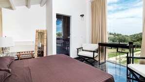 Une chambre avec un grand lit, un bureau, une chaise et une vue sur l’extérieur.