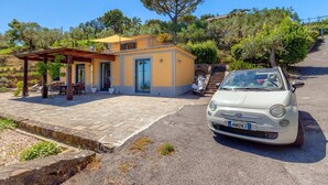 A two-story house with a covered patio, a parked car, and a staircase leading to the upper floor. - Villa Carina with sea views (Sant'Agata Sui Due Golfi)