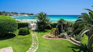 Ein gepflegter Garten mit einem Kiesweg, der zu einem Blick auf das Meer führt.