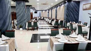 A banquet hall with tables set for dining, featuring a checkered floor pattern and a long, straight layout. - Hôtel du Lac Béjaïa (Béjaïa)