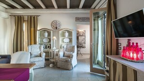 A cozy living room with a fireplace, a television, and a glass door leading to a balcony. - Villa Del Fiore - Private villa with pool (Marausa)
