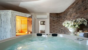 A spa area with a hot tub, wooden walls, and a stone wall with a flower arrangement. - Villa Del Fiore - Private villa with pool (Marausa)