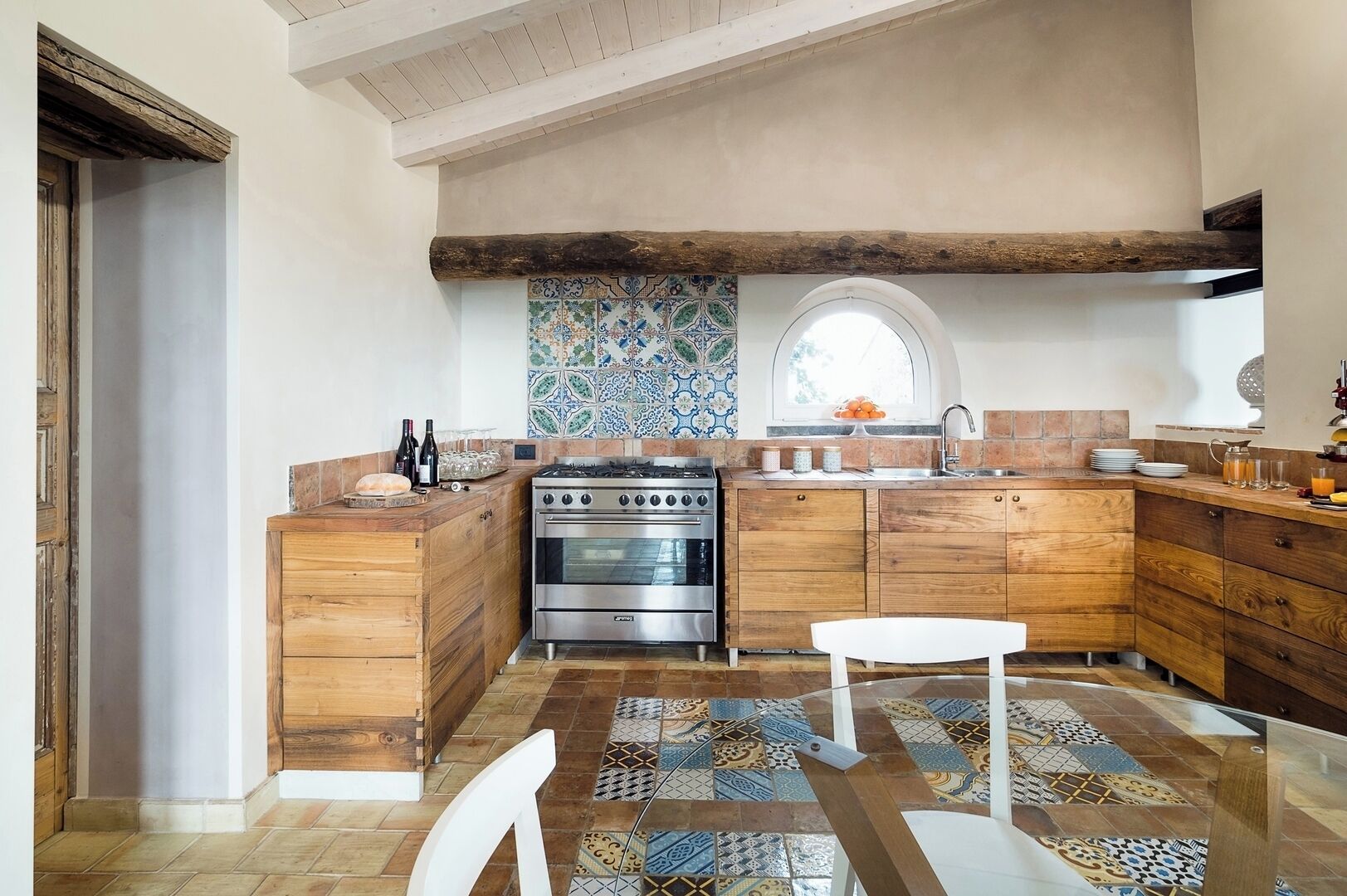A kitchen with wooden cabinets, a stove, and a tiled backsplash.