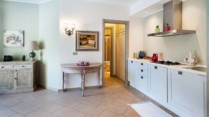 A modern kitchen with white cabinets, a round table, and a doorway leading to a bathroom. - Villa Fiorella - Private villa with heated pool (Ragalna)
