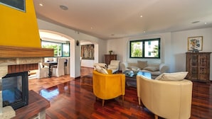 A spacious living area with a fireplace, wooden flooring, and a dining area with a view of the outdoors. - Villa Venera - Coastal Villa with pool in Sumartin (Sumartin)