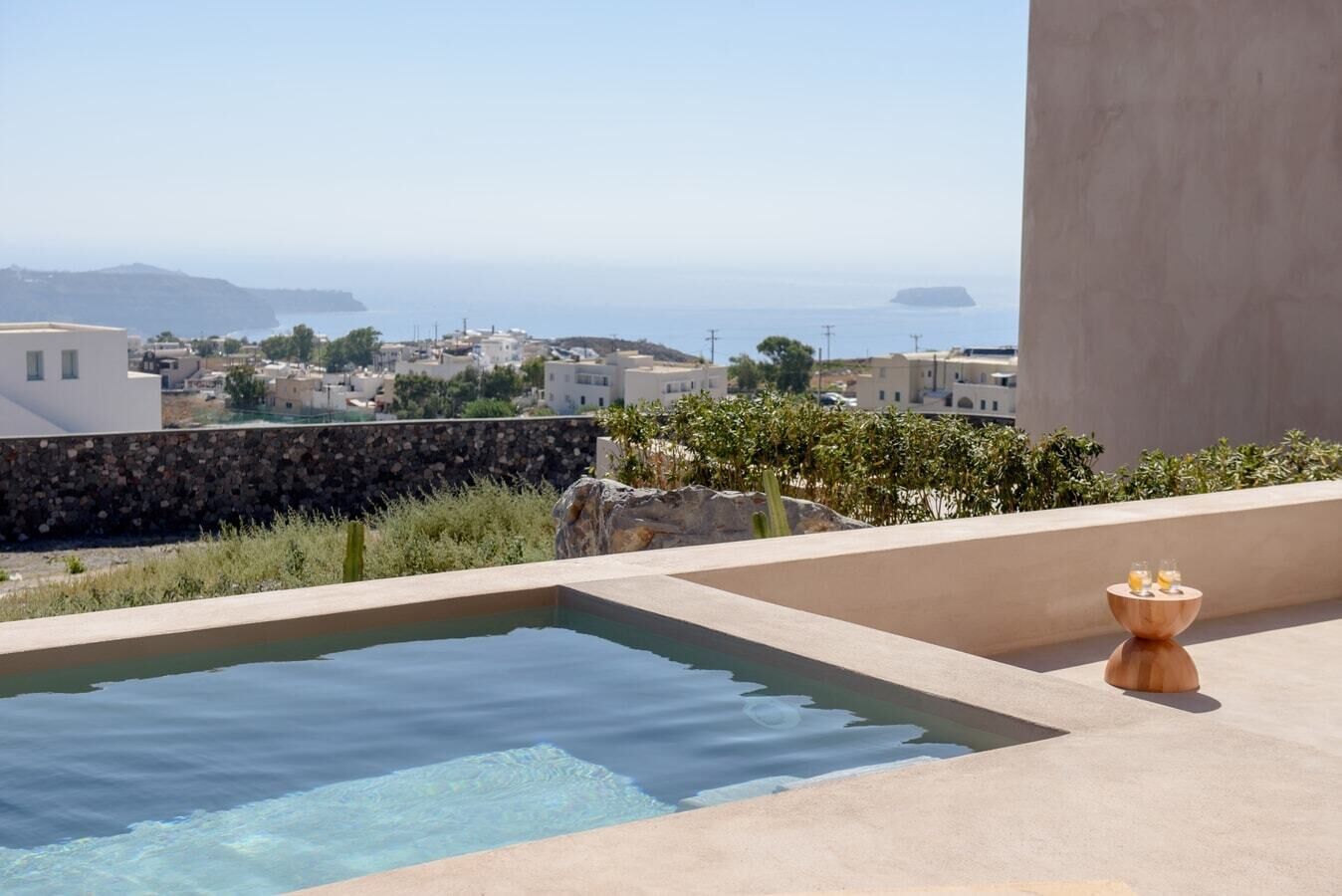 A rooftop pool with a clear view of the sea and distant buildings.