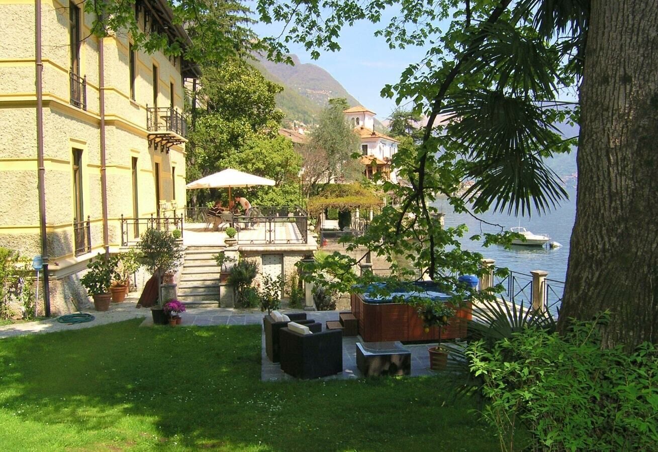 Une cour avec des sièges extérieurs, un jacuzzi et une vue sur l’eau.