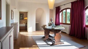 A room with a wooden desk, a hanging light fixture, and a view of greenery through a window with red curtains. - Villa San Francesco - Private villa with pool (Pian di Scò)