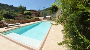 A rectangular swimming pool with a tiled deck, surrounded by a wooden fence and a stone wall. - Villa Pontedera - Countryside cottage with private pool (Capannori)