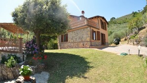 A stone building with a tiled roof, a wooden pergola, and a well-maintained lawn. - Villa Pontedera - Countryside cottage with private pool (Capannori)