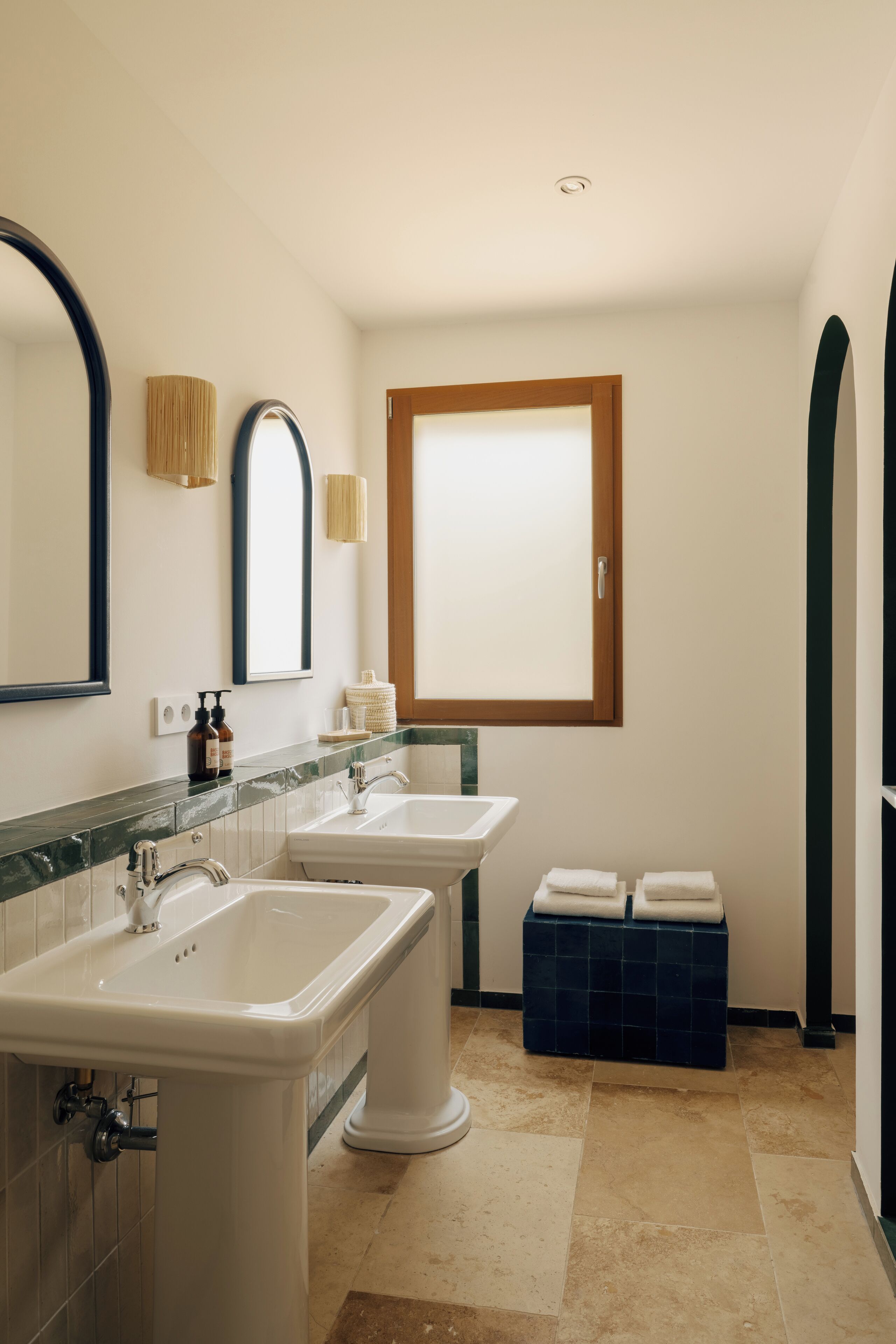 A bathroom with two sinks, a mirror, and a window.