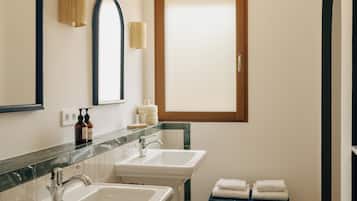 A bathroom with two sinks, a mirror, and a window.