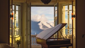 A grand piano in a room with large windows overlooking a mountainous landscape. - Villa Oltre Le Nuvole - Luxury villa with lake views (Pigra)