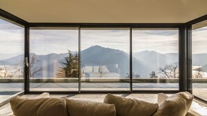 A room with a large window offering a mountain view. - Villa Oltre Le Nuvole - Luxury villa with lake views (Pigra)