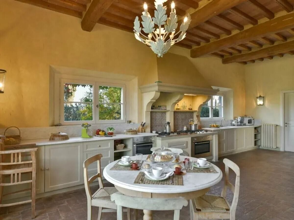 Une cuisine spacieuse avec un îlot central, des chaises en bois et une table à manger dressée pour le repas.