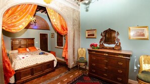 Un dormitorio con cama, cómoda, silla y espejo.