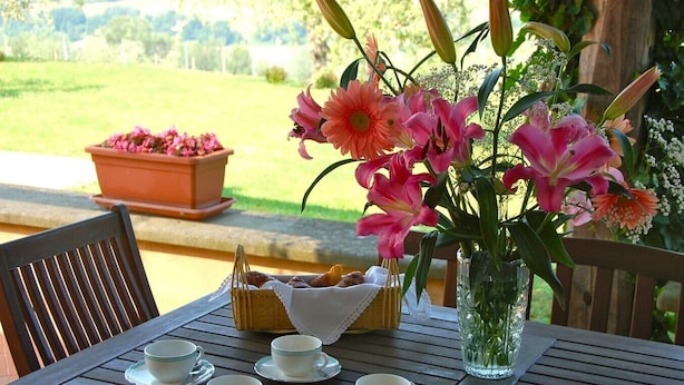A wooden table with a floral arrangement, a basket of pastries, and several white cups and saucers. - Villa Maria - Countryside villa with a private pool (Magliano Sabina)