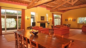 A spacious living room with a wooden dining table, red sofas, and a fireplace. - Villa Maria - Countryside villa with a private pool (Magliano Sabina)