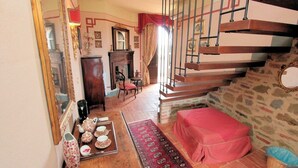 A traditional interior with a staircase, a fireplace, and a dining area with tea set. - Villa Luna - Umbrian farmhouse with private pool (Castiglione del Lago)