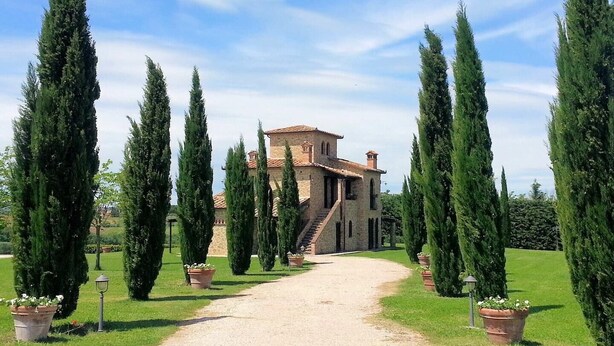 A stone building with a tiled roof, a staircase leading to a door, and a gravel path flanked by tall cypress trees. - Villa Luna - Umbrian farmhouse with private pool (Castiglione del Lago)