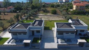 Et moderne boligkompleks med flere separate huse, alle med fladt tag og en lille forhave.