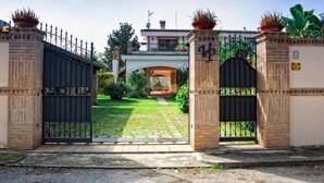 Une entrée fermée par un portail, avec un chemin pavé menant à un bâtiment.